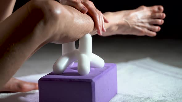 Low extreme closeup view of mature woman using a massage tool for myofascial therapy on her leg’s ca