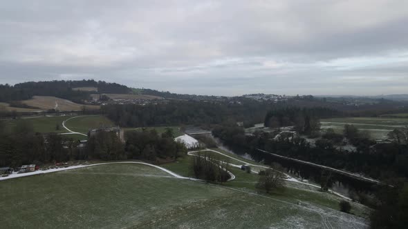 Drone shot of a snowy valley with a river flowing through it.