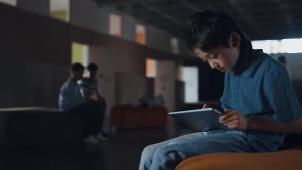 Addicted Pupil Use Tablet Computer Sitting Alone in School