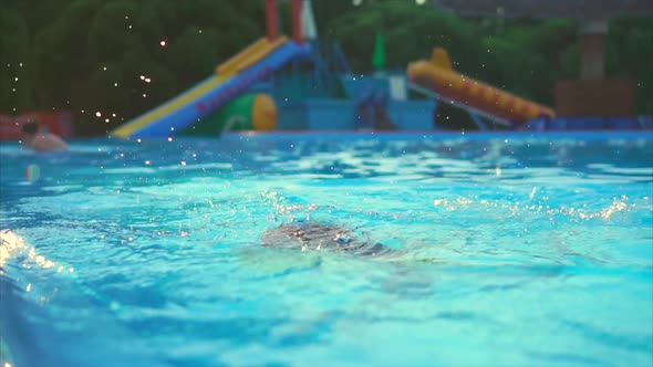 Cute and Young Girl Dives Into the Pool in Order to Cool Off on a Hot Day