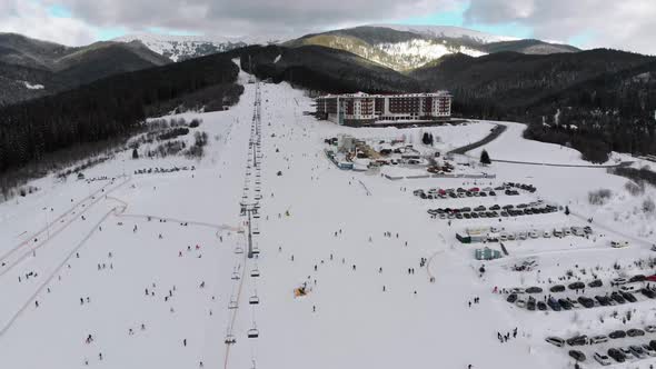 Aerial View on Lot of People Skiing on Ski Slopes Near Ski Lifts on Ski Resort