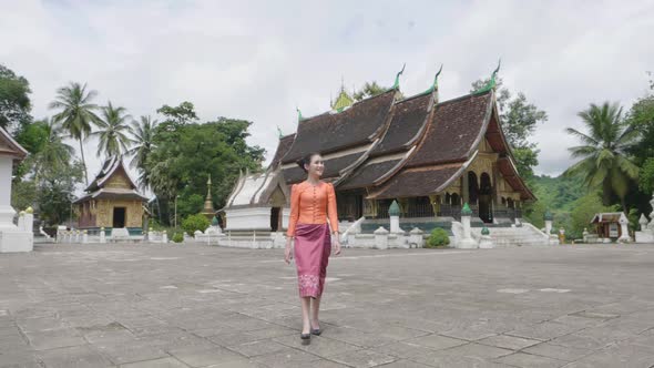 Beautiful Asian Girl Walking At Wat Xieng Thong Landmark In Luang Prabang