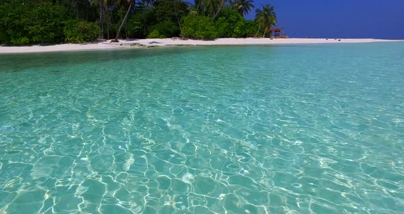 Beautiful above island view of a white sand paradise beach and aqua blue water background in 4K