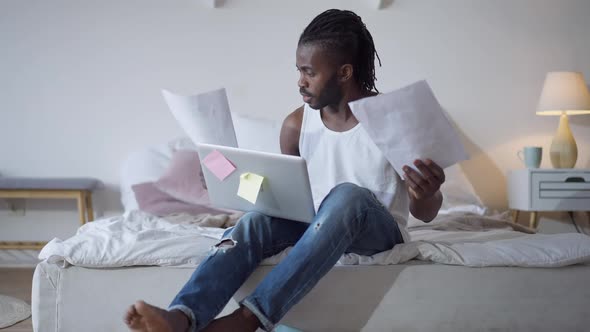 Portrait of Annoyed African American Young Man Using Virtual Conference Talking and Analyzing