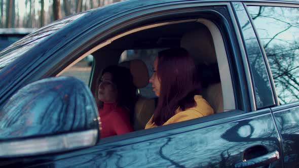 Young Women Sitting in Car and Talking