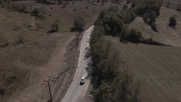 Aerial white car on dirt road