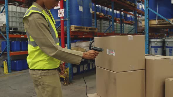 Young female worker using barcode scanner in a warehouse