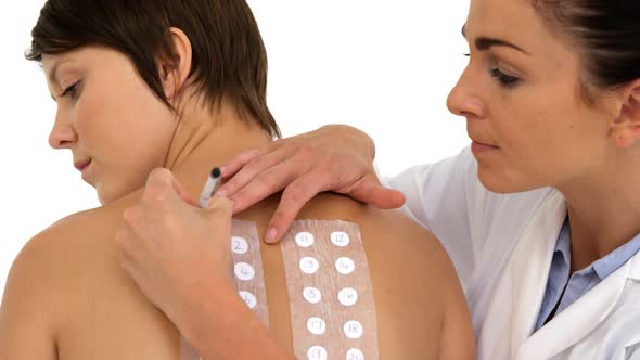 Woman therapist writing something on the back of her patient