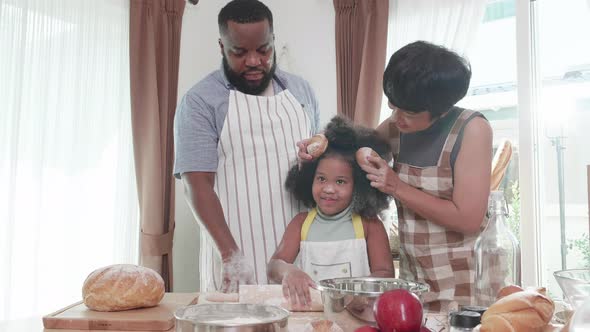 Kitchen fun. Happy African American family wearing aprons dancing and cooking together