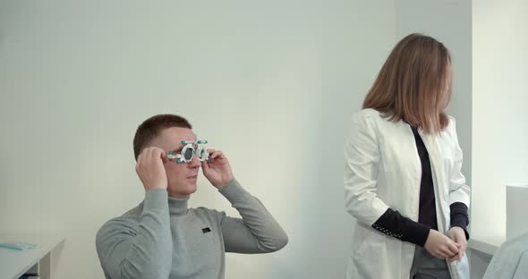 Young Man with a Short Haircut in the Office Checking Eyesight