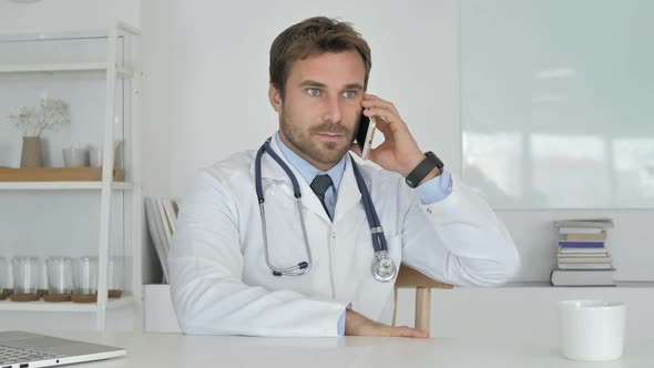 Doctor Talking on Phone with Patient Discussing Medical Report