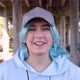 Blue haired teen girl wearing hoodie and baseball cap and smiling against bridge pillars - VideoHive Item for Sale