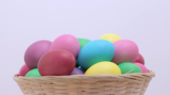 Easter Colorful Chicken Eggs Rotating in Basket on Light Background