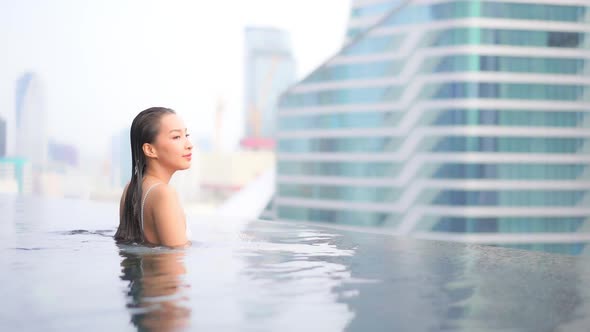 Young asian woman enjoy around outdoor swimming pool for leisure