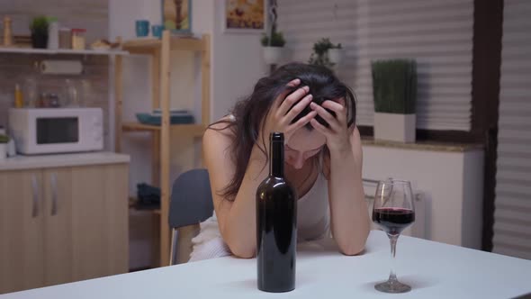 Drunk Woman Sitting in the Kitchen