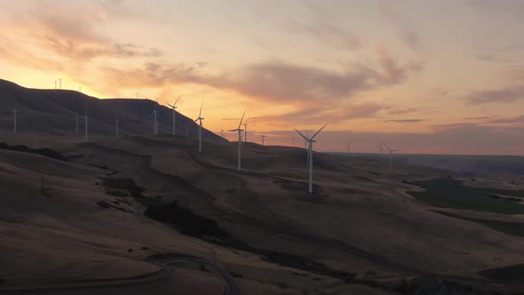 Aerial Landscape View of Wind Turbines on a Windy Hill during a colorful sunrise. Taken in Washingto