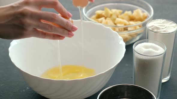  Woman's Hands Break the Eggs Into White Bowl.