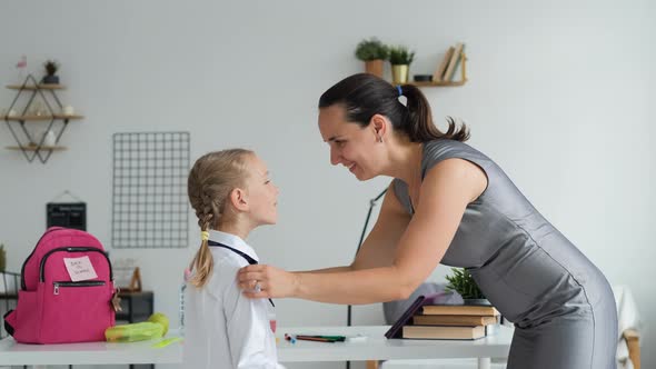 Mother Helping Pupil Girl Get Ready for School