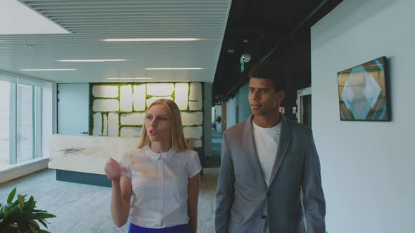 Diverse Colleagues Walking in Office and Talking. Young Woman with Black Man Walking in Modern