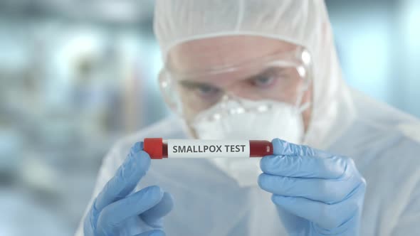 Defocused Laboratory Assistant Examines Vial with Smallpox Test