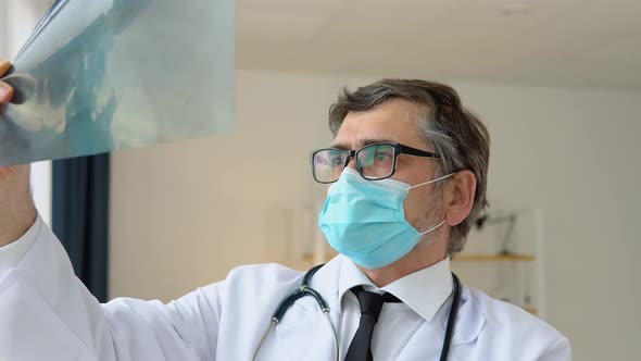 Senior Doctor 50s Examining an Xray of the Lungs