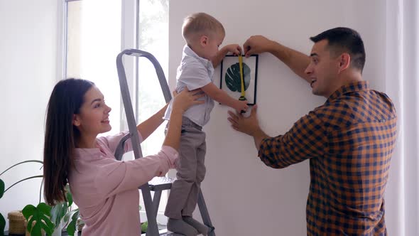 Home Repair, Cute Child with Measuring Tape Helps To Parents Make Repairs and Hang Picture in