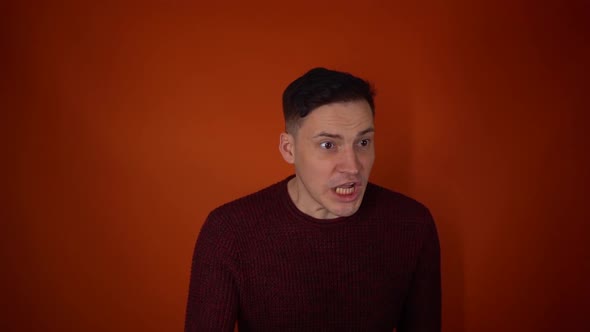 Portrait of Angry Man on Orange Background