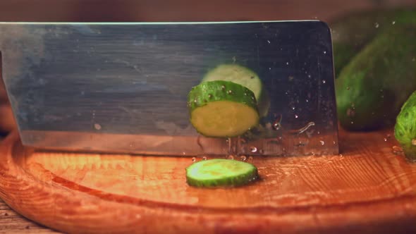 Super Slow Motion with a Large Knife Cut Off the Pieces From the Cucumber