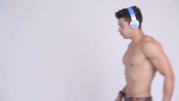 Young Handsome Muscular Shirtless Man Jogging and Checking Smartwatch