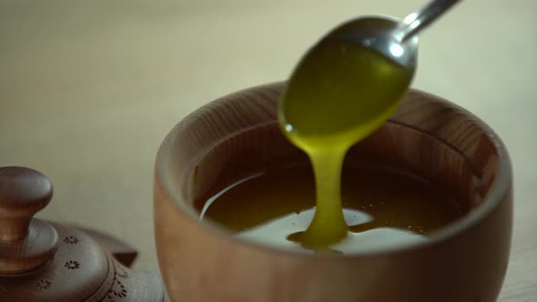 Thick Honey Dripping From the Spoon Close Up