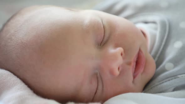 Close-up Portrait of a Beautiful Newborn Baby Sleeping in the Bed