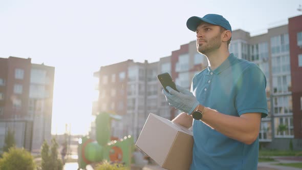 Male Courier Man is Looking for Mobile Phone to Deliver Address of Food From a Shop