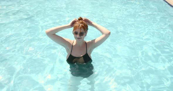 Young Woman in Sunglasses is Dancing in Swimming Pool in a Water Park