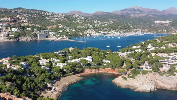 Port Andratx in Mallorca Spain with resorts, boats and homes by Marmassen Cove, Aerial dolly right w