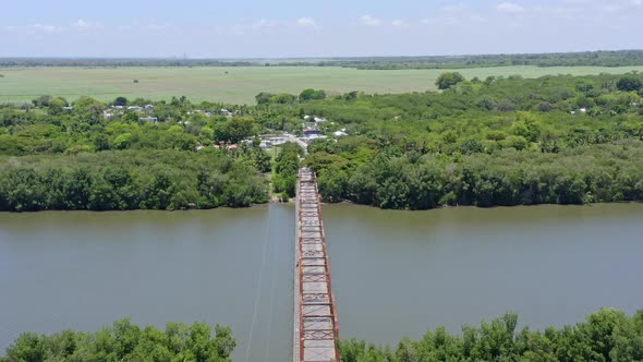 Old Bridge Over Peaceful River Of Soco At San Pedro de Macoris In Dominican Republic. Aerial Pullbac