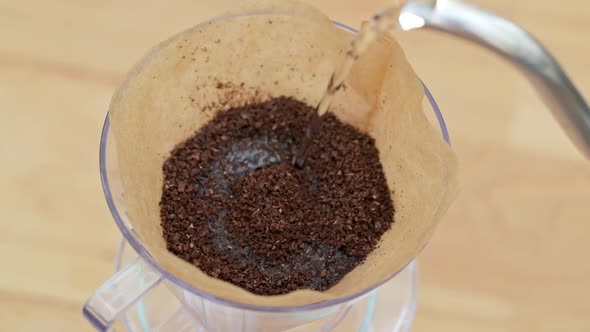 Barista pours water into the filter with coffee