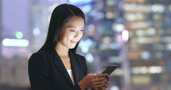 Young businesswoman use of cellphone at night