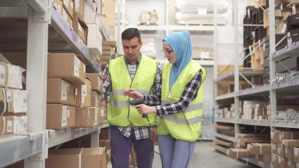 Man Store Worker Shows a Muslim Woman How To Use a Barcode Scanner