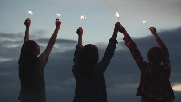 Group of a young teen Asian woman holding sparklers celebrating new Year with friends.