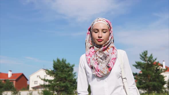 Young Arab Woman Walking Down the Street Wearing a Hijab in a Modern City