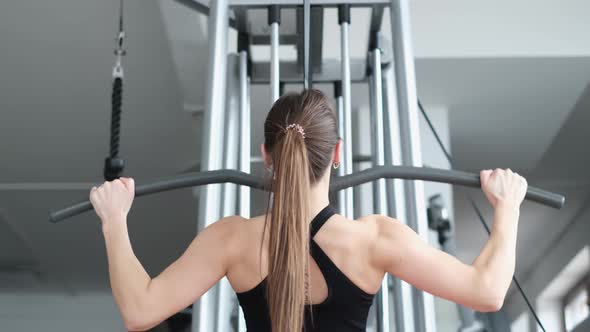 Athletic Woman Trains the Back Muscles in the Gym She Pumps the Main Muscle Groups