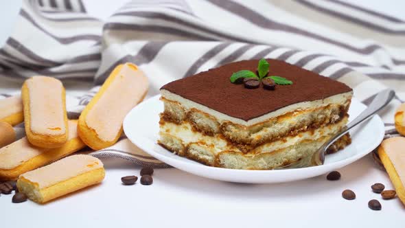 Tiramisu Dessert Portion on Ceramic Plate, Savoiardi Cookies and Coffee Beans