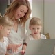 Mom with Daughters Blonde Twins Sitting at a Laptop - VideoHive Item for Sale