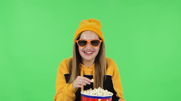 Portrait of Modern Girl in Yellow Hat in 3D Glasses Is Watching a Funny Movie , Eating Popcorn and