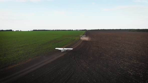 A Small Airplane Takes Off From a Field.at Sunrise