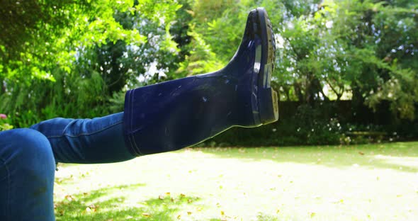 Man carrying woman in wheelbarrow in garden