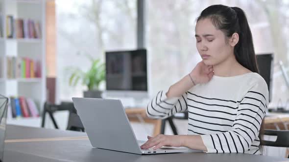 Laptop Use By Young Asian Woman with Neck Pain in Office