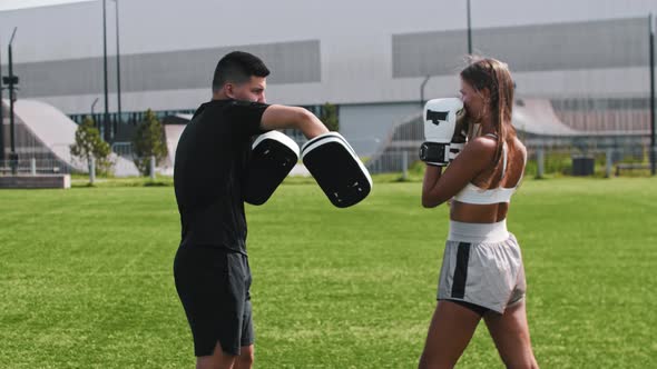 Young Woman Having a Boxing Training with Her Male Coach