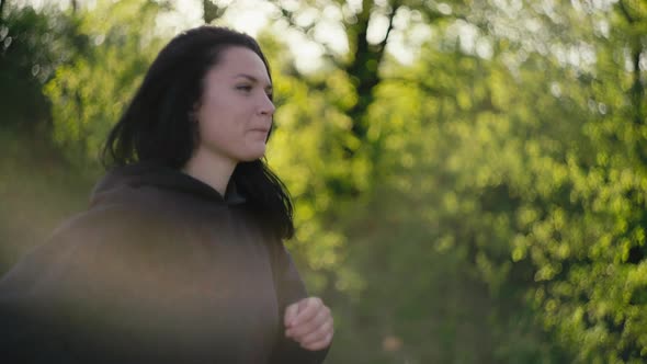 Closeup of a Caucasian Woman Running at Sunset in the Park