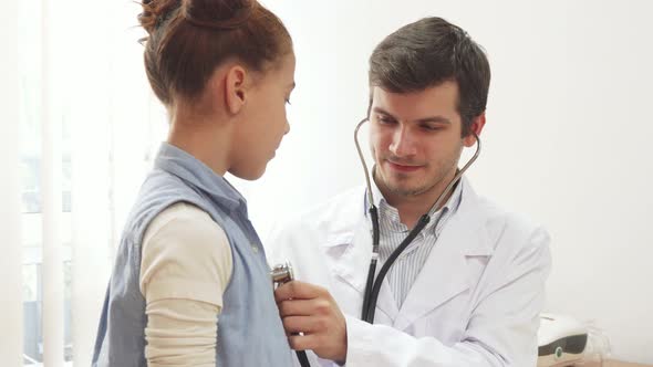 The Attentive Doctor Listens To the Lungs of a Small Patient with a Stethoscope